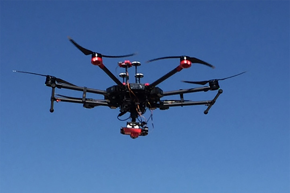 Photo of drone in the air as the landing gear folds up during flight. This allows the camera an unobstructed view.