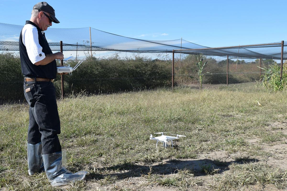 Dr. Wayne Woldt adjusts settings on the controller before flying the unmanned aircraft. The drone will take video of a gamebird operation..