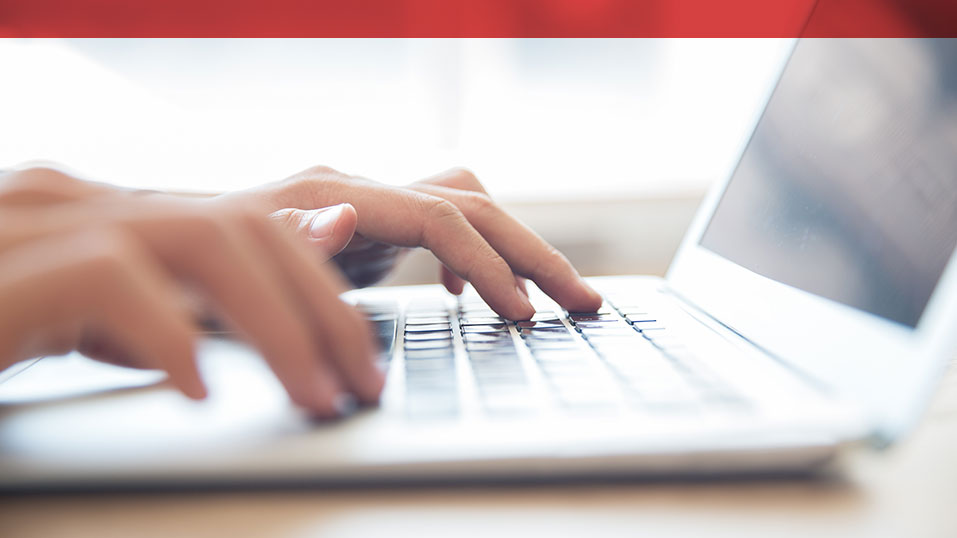 Photo of hands typing on a laptop.